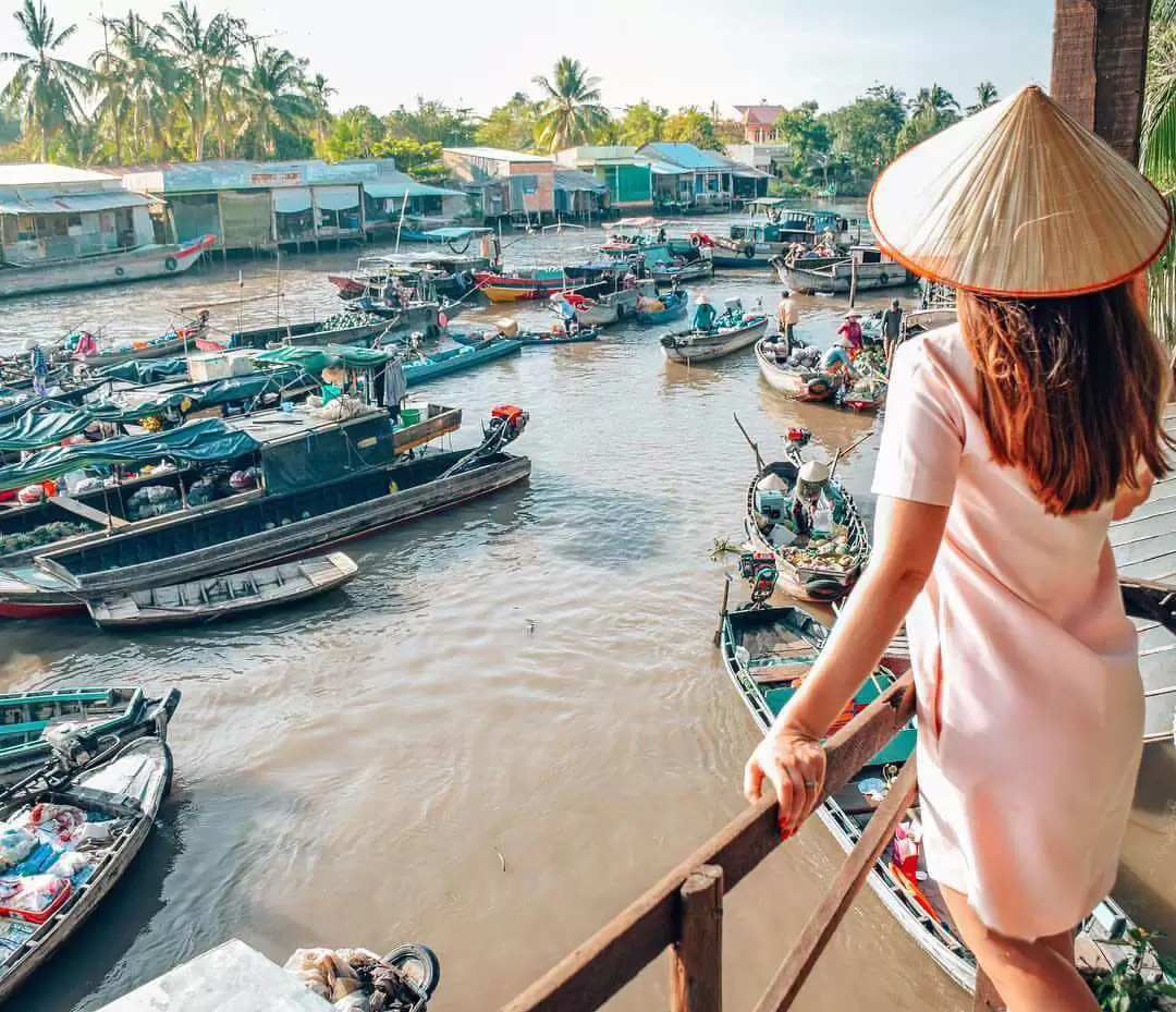 A female tourist taking photo in Cai Be floating market